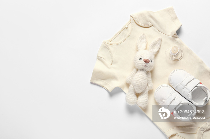 白色背景的婴儿衣服、鞋子、玩具和奶嘴