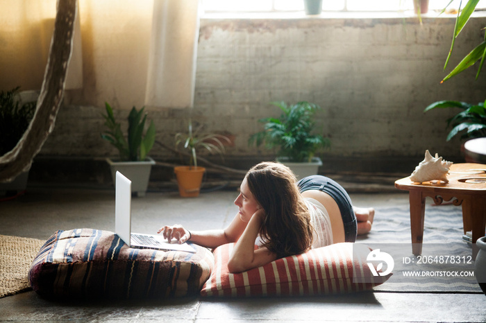 Young woman using laptop in living room