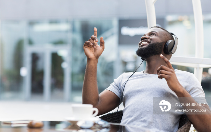 Young african american guy enjoying music in headphones