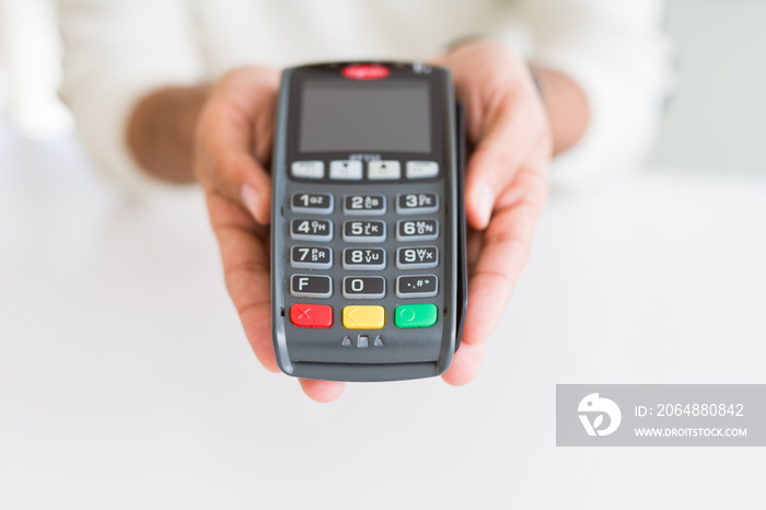 Close up of man hands holding point of sale terminal, dataphone for shopping paying using credit car