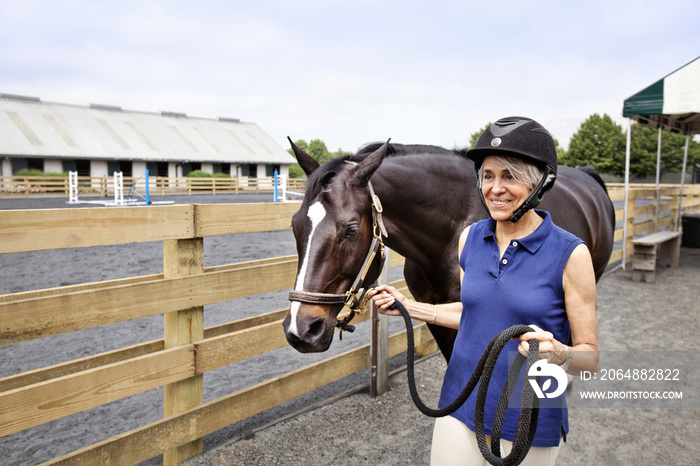 Jockey walking with horse against sky