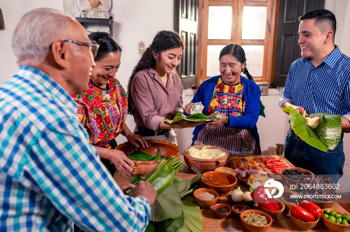 Abuela enseña a sus nietos universitarios a cocinar tamales, platillo tradicional de Guatemala.