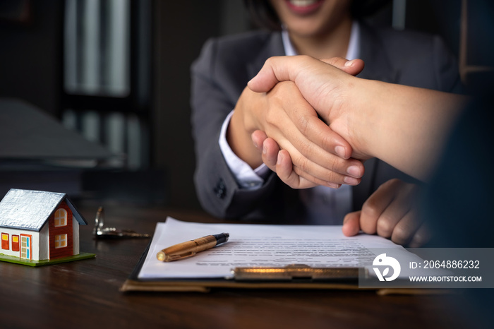 Estate agent shaking hands with his customer after contract signature