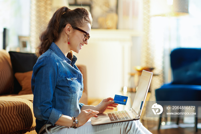 happy young woman making online purchases on laptop