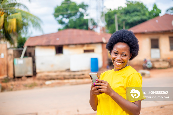 excited black African millennial girl with afro haired using modern smartphone checking social media