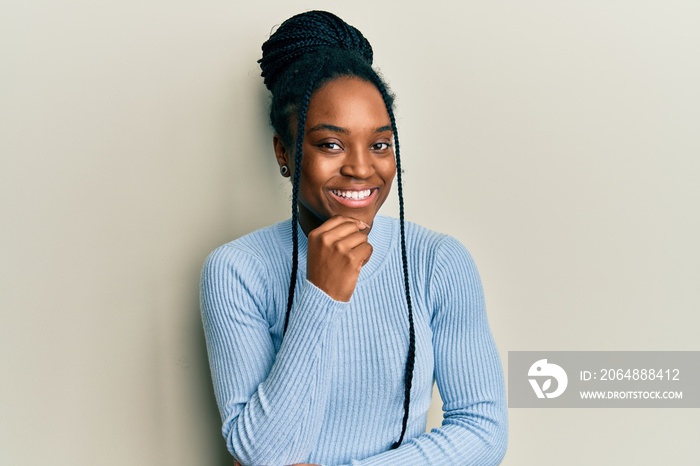 African american woman with braided hair wearing casual blue sweater smiling looking confident at th