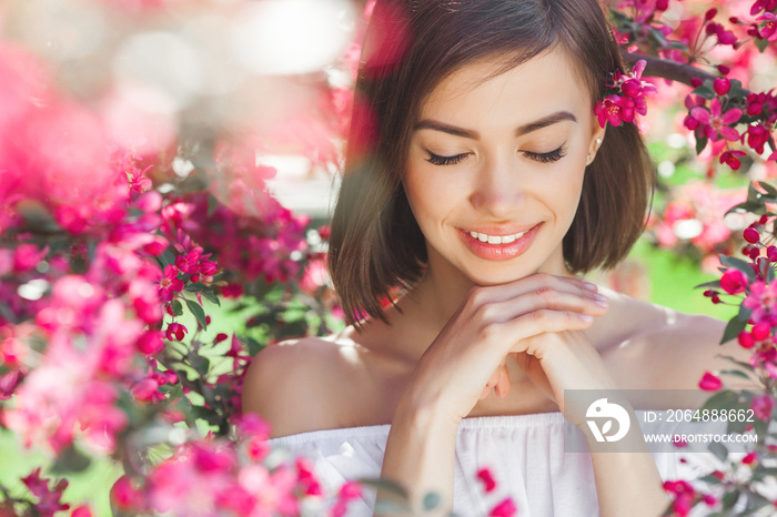 Beauty portrait of young woman closeup. Attractive female in flowers with copy space. Beautiful lady