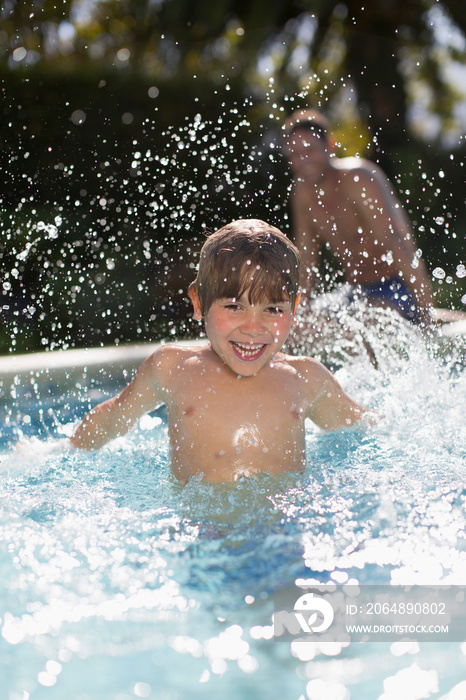 嬉戏男孩在阳光明媚的游泳池戏水的肖像