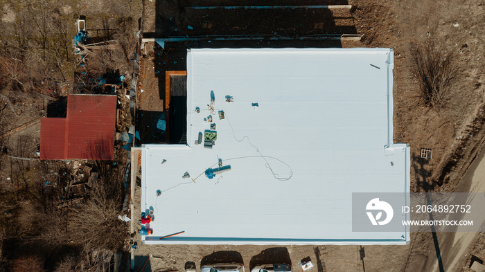 Aerial view of an apartment building with flat roof in construction, ballasted system with geotextil