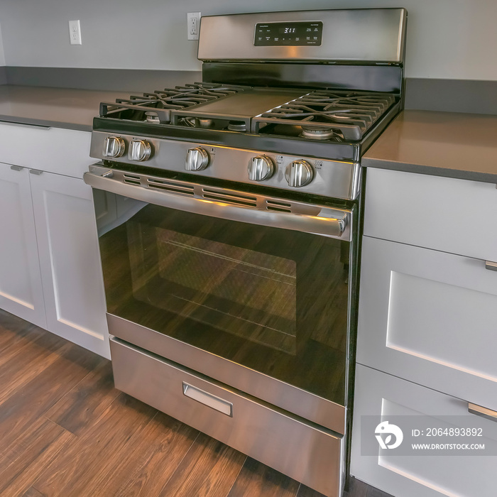 Frame Square Range and wall mounted microwave inside the kitchen with brown wooden floor