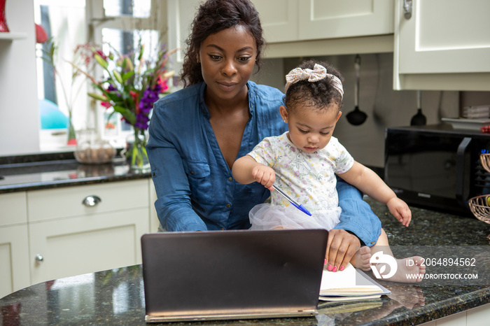 在家用笔记本电脑工作并照顾婴儿女儿（12-17个月）的女性
