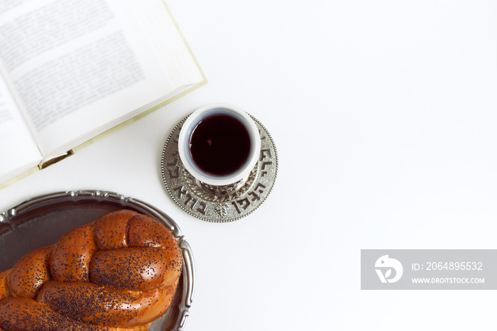 Shabbat Shalom, challah with glass of wine on a white background. Not isolated, copy space, author p