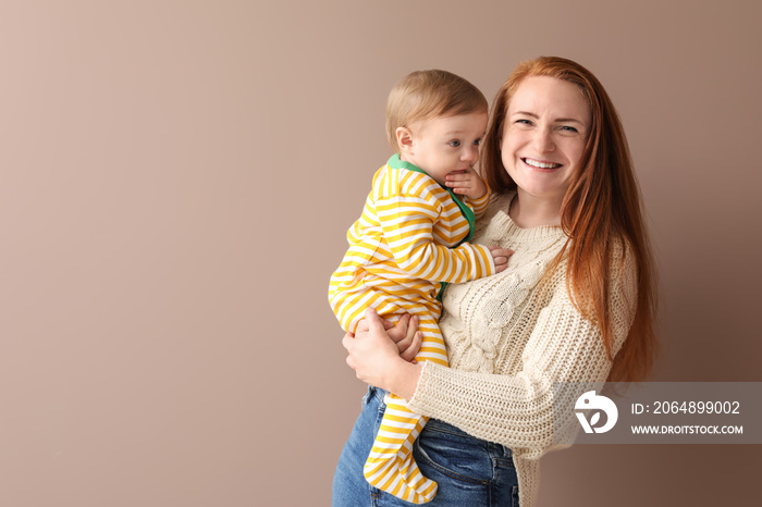 Portrait of happy mother with her little baby on color background