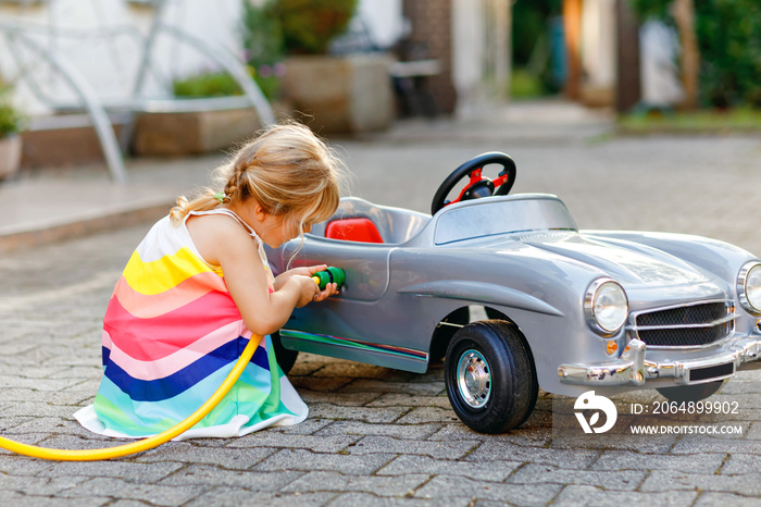 蹒跚学步的小女孩在夏天玩老式玩具车，在户外玩得很开心。可爱的孩子r