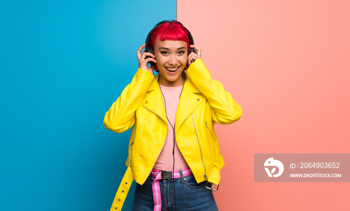 Young woman with yellow jacket listening to music with headphones