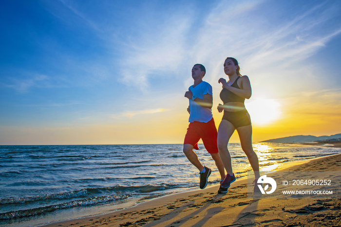 日落时分，男人和女人在热带海滩上奔跑