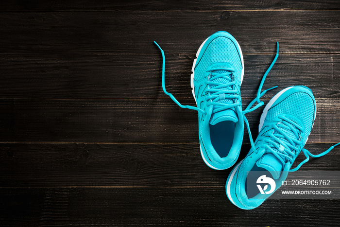 一双木制背景的蓝色运动鞋。