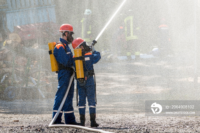 Jugendfeuerwehr mit Atemschutz bei der Übung löscht im Wassernebel