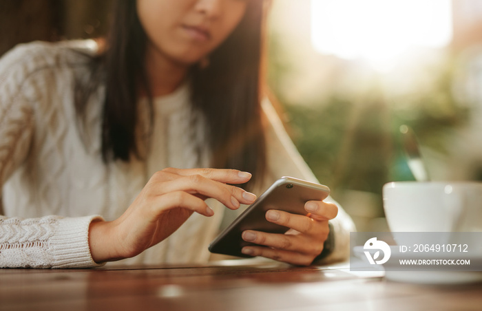 Woman sitting at a table using mobile phone