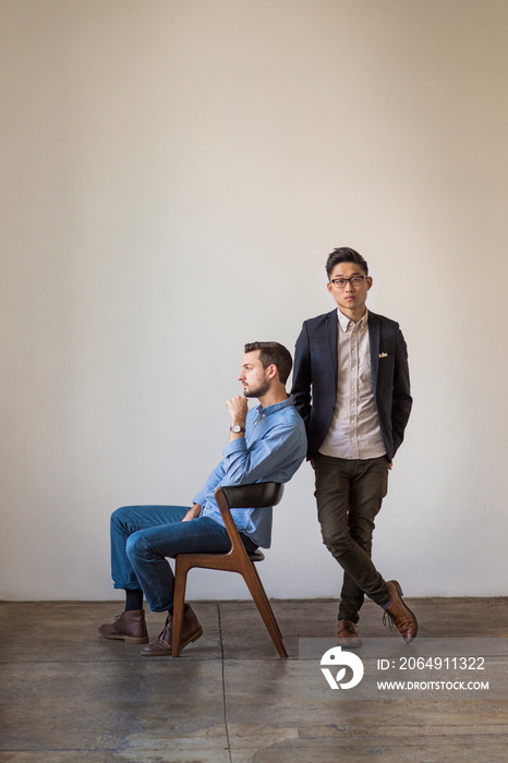 Young men posing in front of wall