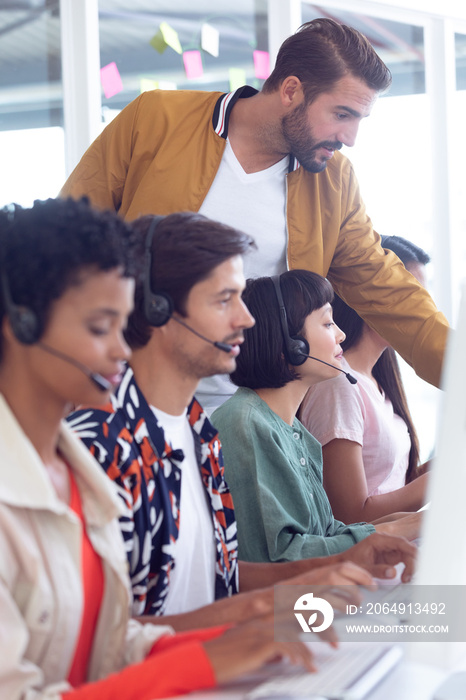 Customer service executive trainer assisting her team at desk