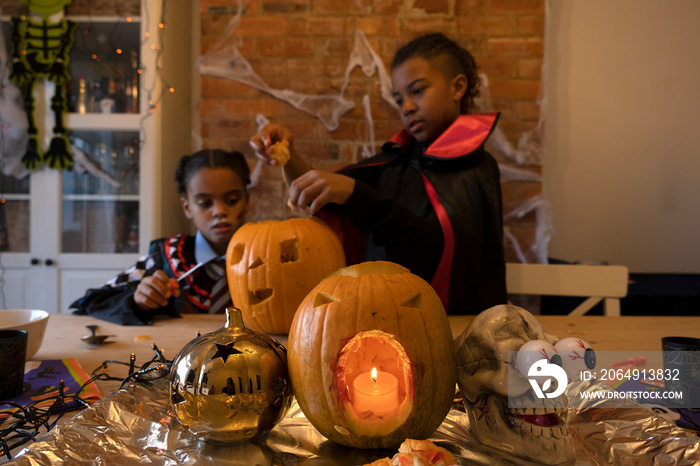 Children in Halloween costumes making Jack�OLantern