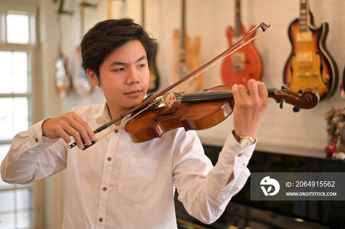 Asian Violinist playing the violin at the home. Musician playing at home.