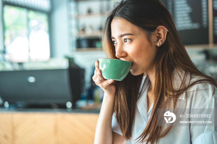 Asian woman in a cafe drinking coffee .Portrait of Asian woman smiling in coffee shop cafe vintage c