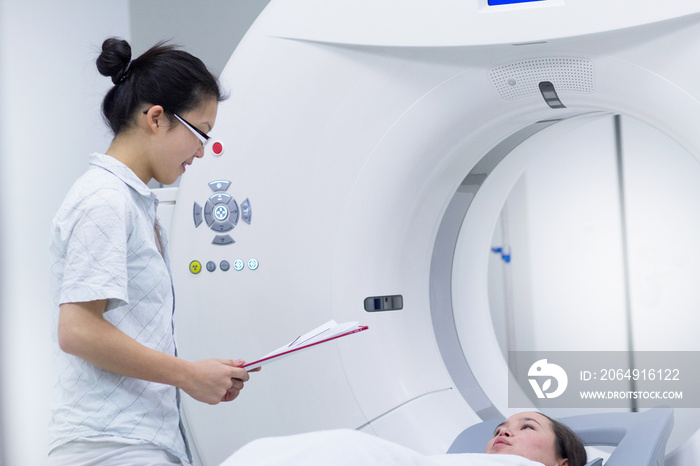 Technician with patient in CT scanner