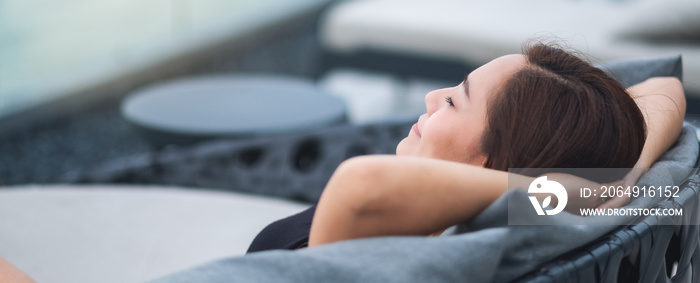 A beautiful young asian woman relaxing sleeping and lying down on sofa outdoors