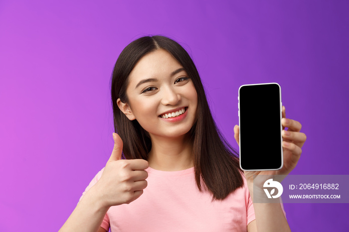 Close-up satisfied happy attractive modern asian woman give positive feedback, show smartphone displ