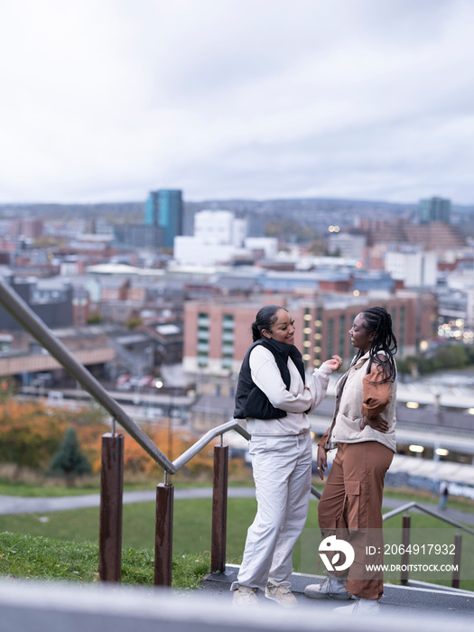 Smiling friends standing on steps in city