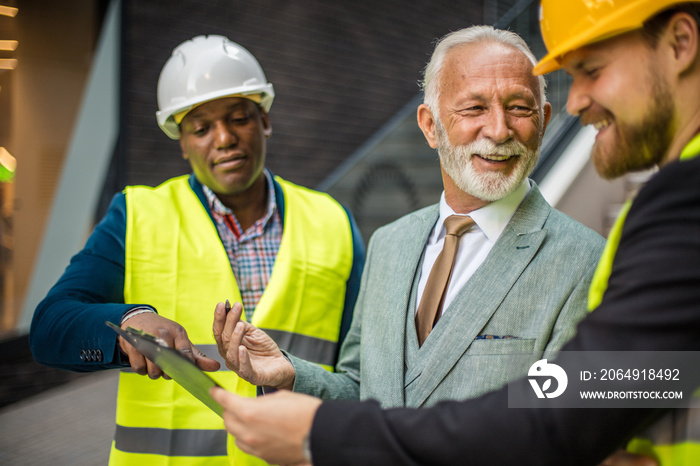 The construction site boss has a conversation with the architects.