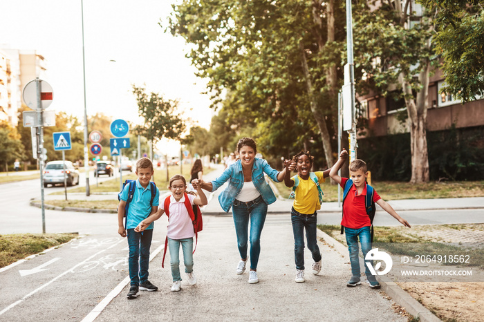 Happy children enjoying outdoors with their teacher.