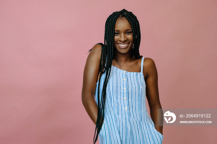 smiling young black woman with braids in studio portrait