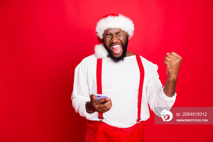 Portrait of crazy african christmas father raising fists screaming yes got noel news like holding ce