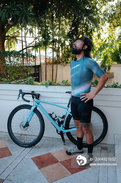 A bearded cyclist practising breathing exercise for his morning bike ride