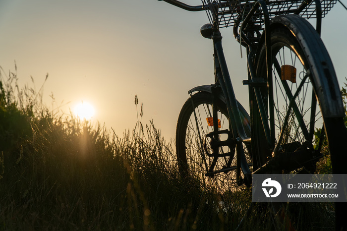 复古经典自行车，自然绿色背景，草地上的水湖河日落