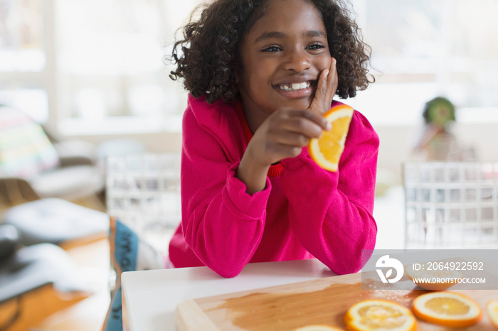 Young girl about to eat orange slice