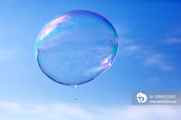一个干净的肥皂泡在空中飞舞，蓝天。