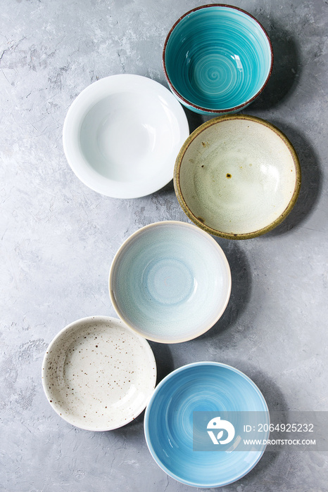 空的彩色陶瓷碗系列。各种餐具灰色纹理背景。俯视图