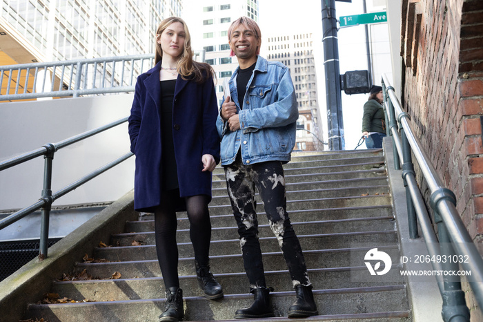 Lgbtqia friends posing on stairs outside.