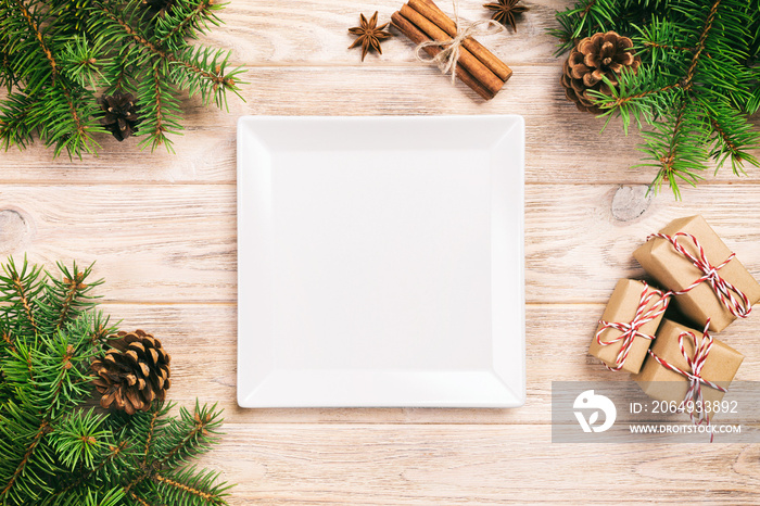 木制桌子上的白色方形盘子。带有圣诞装饰，方形空盘子。新年概念