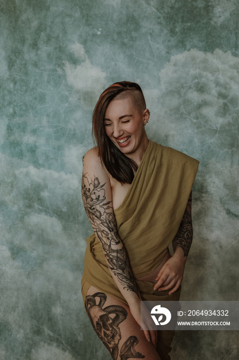 portrait of a Native American woman with a side shave and tattoos laughing