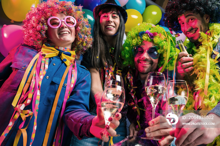 Glückliche Party Freunde feiern karneval und stoßen mit Sekt an.