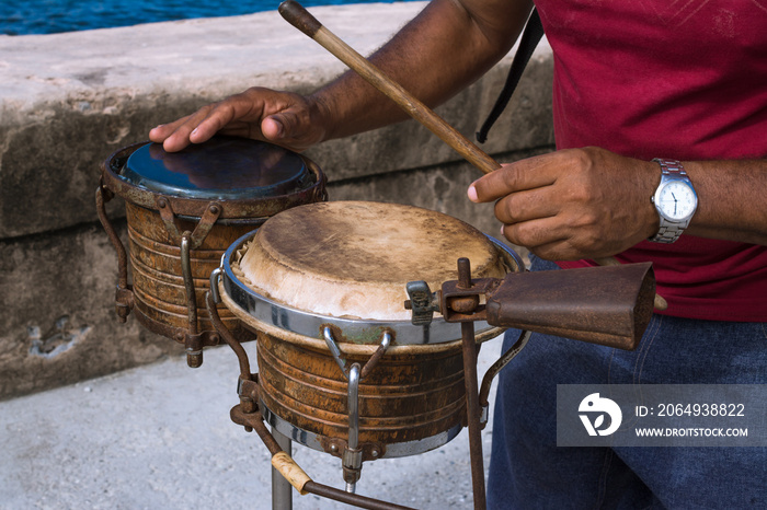 El músico toca los bongós en el malecón de la Habana Cuba para alegrar el ambiente.