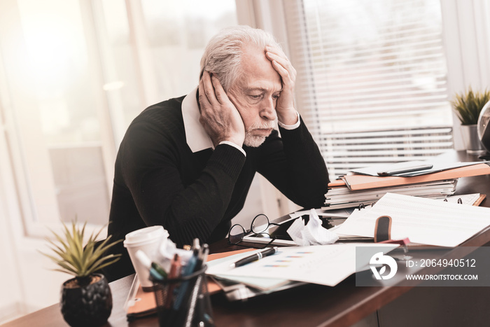 Overworked businessman sitting at a messy desk