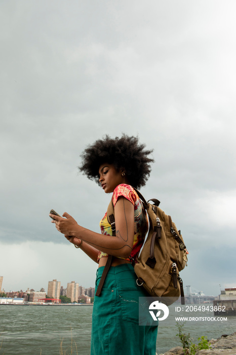 美国，纽约市，河边背着背包的年轻女子