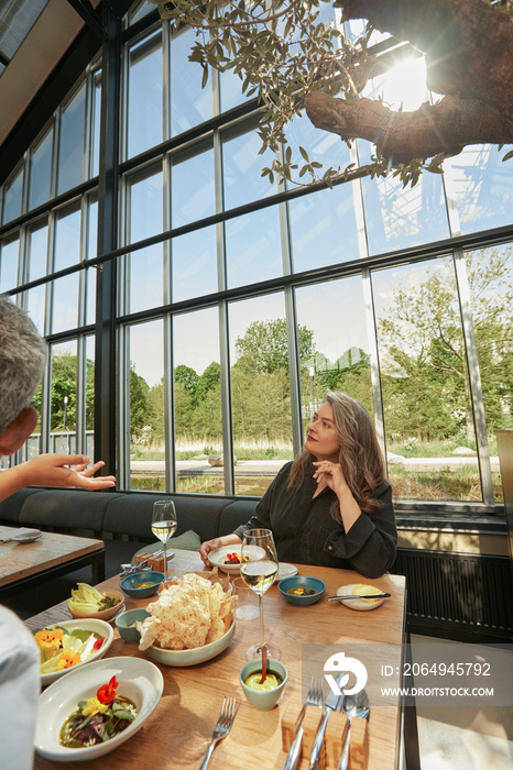 Mature woman sitting at table in restaurant