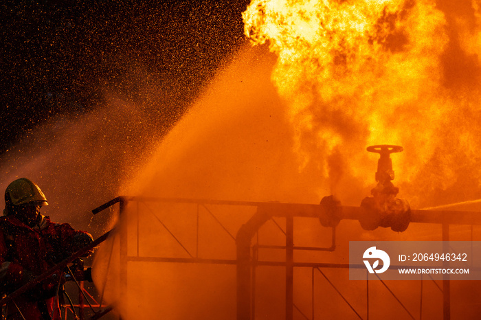 消防员使用水雾喷射石油钻机工厂爆炸的火焰